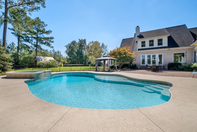 view of pool featuring a pool with connected hot tub, fence, a gazebo, and a patio