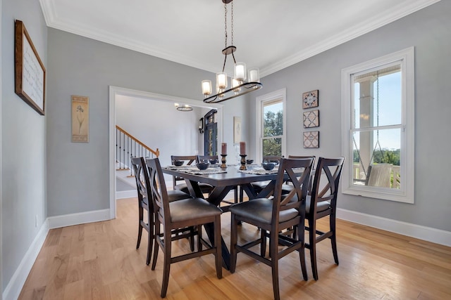 dining room with ornamental molding, light wood finished floors, stairs, and baseboards