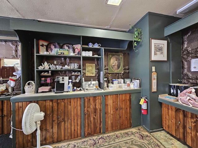 bar with sink and a textured ceiling