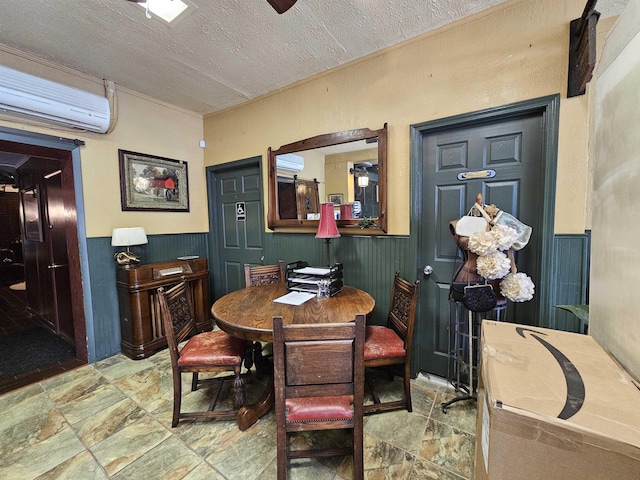 dining room featuring a wall mounted AC and a textured ceiling