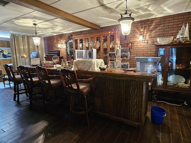 bar with brick wall, decorative light fixtures, and beam ceiling