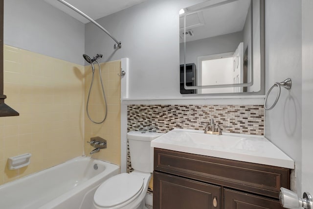 full bathroom featuring backsplash, vanity, tiled shower / bath combo, and toilet