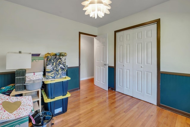 interior space featuring a notable chandelier, light wood-type flooring, and a closet