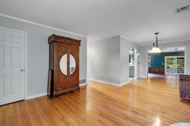 foyer featuring crown molding and light hardwood / wood-style flooring