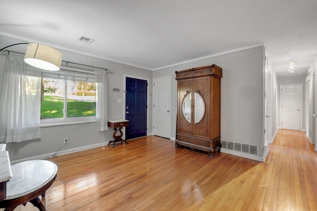 entryway with light hardwood / wood-style flooring and ornamental molding