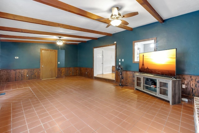 unfurnished living room with beamed ceiling and ceiling fan