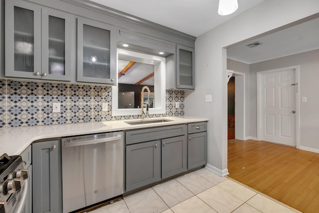 kitchen with gray cabinetry, sink, decorative backsplash, light tile patterned flooring, and stainless steel appliances