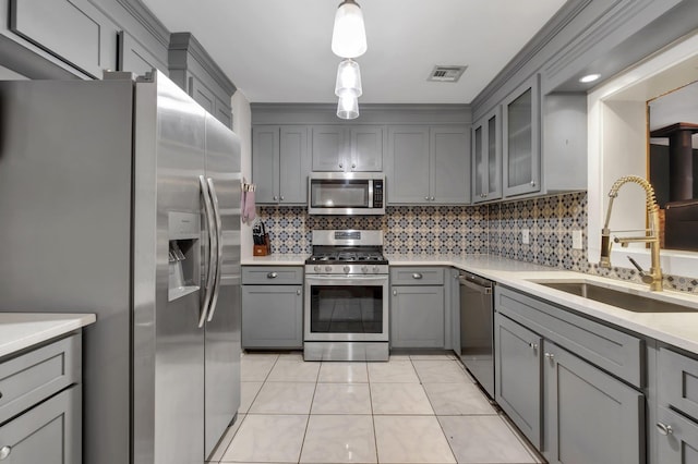 kitchen featuring gray cabinetry, sink, hanging light fixtures, light tile patterned flooring, and appliances with stainless steel finishes