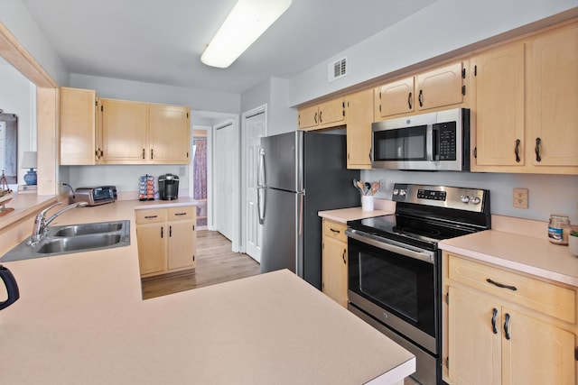 22 Lighthouse Pt, Crawfordville, FL 32327 - kitchen featuring stainless steel appliances, light brown cabinets, light countertops, light wood-type flooring, and a peninsula