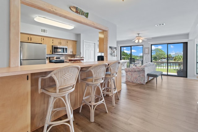 22 Lighthouse Pt, Crawfordville, FL 32327 - kitchen with stainless steel appliances, open floor plan, light countertops, light wood-style floors, and ceiling fan