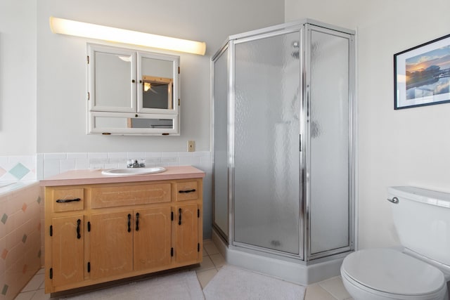 22 Lighthouse Pt, Crawfordville, FL 32327 - bathroom with tile patterned floors, tile walls, a shower stall, vanity, and wainscoting