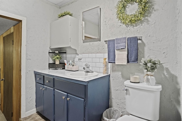 20158 NW Evans Ave, Blountstown, FL 32424 - bathroom featuring vanity, tasteful backsplash, toilet, a textured wall, and crown molding
