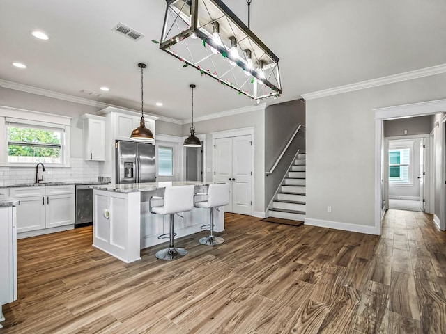 2288 Wabash Trl, Tallahassee, FL 32303 - kitchen featuring stainless steel refrigerator with ice dispenser, beverage cooler, a kitchen island, white cabinets, and ornamental molding