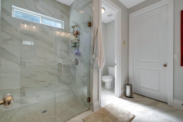 bathroom with toilet and a shower with door