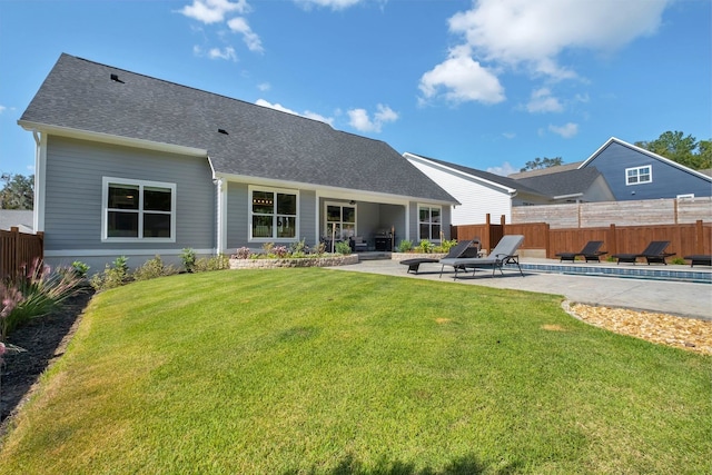 rear view of house with a yard and a patio