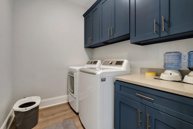 washroom featuring cabinets, light hardwood / wood-style floors, and independent washer and dryer