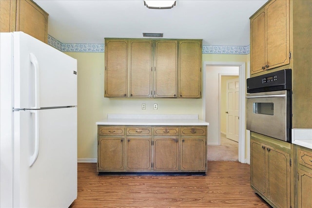711 Kenilworth Rd, Tallahassee, FL 32312 - kitchen featuring freestanding refrigerator, stainless steel oven, light countertops, and light wood-type flooring