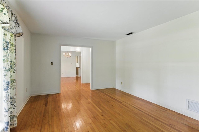 711 Kenilworth Rd, Tallahassee, FL 32312 - spare room with a chandelier and light wood-type flooring