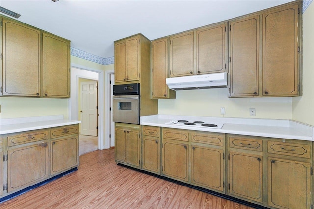 711 Kenilworth Rd, Tallahassee, FL 32312 - kitchen with stainless steel oven, under cabinet range hood, white electric stovetop, light wood-style flooring, and light countertops