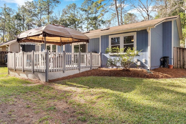 back of house with a gazebo, a lawn, and a deck