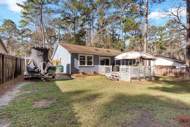 rear view of house with a gazebo, a deck, and a lawn