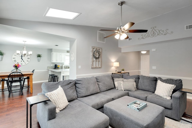 living room with lofted ceiling, ceiling fan with notable chandelier, and wood-type flooring