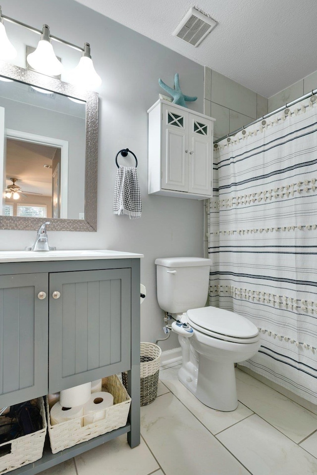 bathroom featuring vanity, toilet, curtained shower, and a textured ceiling