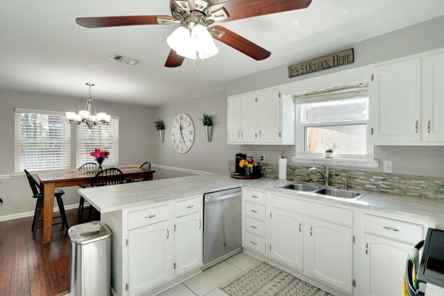 kitchen with decorative light fixtures, dishwasher, white cabinetry, sink, and kitchen peninsula