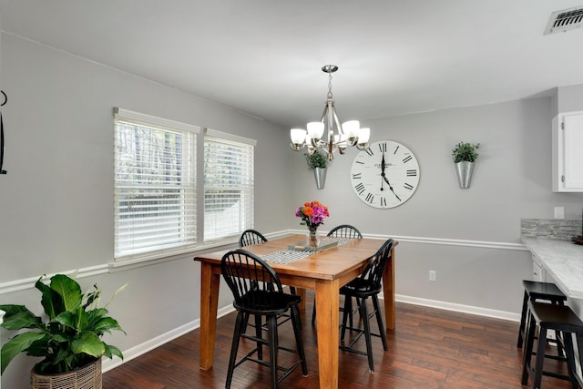 dining space featuring an inviting chandelier and dark hardwood / wood-style flooring