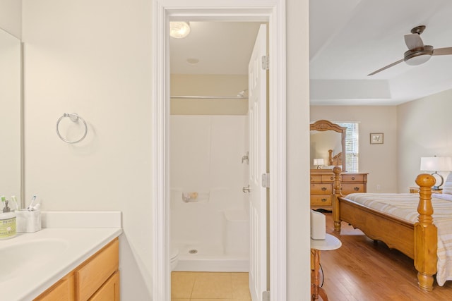 bathroom with a shower, hardwood / wood-style floors, vanity, and ceiling fan