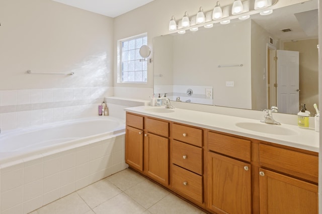 bathroom with vanity, tile patterned flooring, and tiled bath