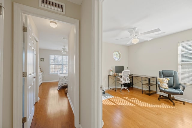 office with hardwood / wood-style flooring and ceiling fan