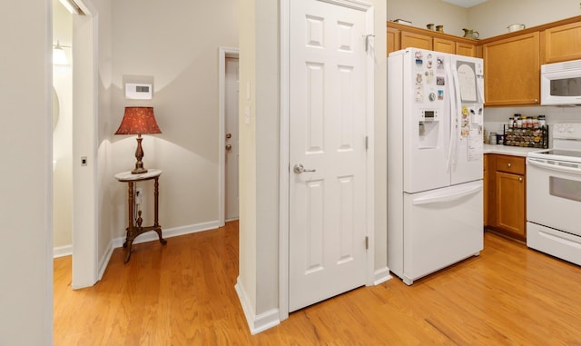 kitchen featuring backsplash, white appliances, and light hardwood / wood-style flooring