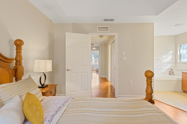 bedroom with multiple windows and light wood-type flooring