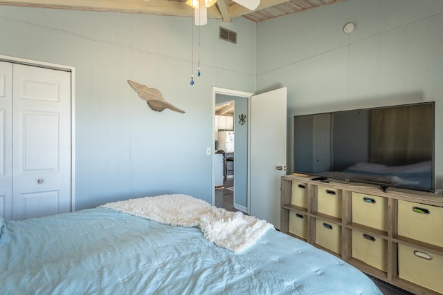 bedroom featuring a closet, ceiling fan, and vaulted ceiling with beams