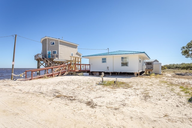 rear view of house featuring a deck with water view