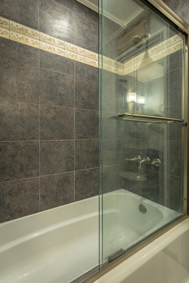 bathroom with bath / shower combo with glass door