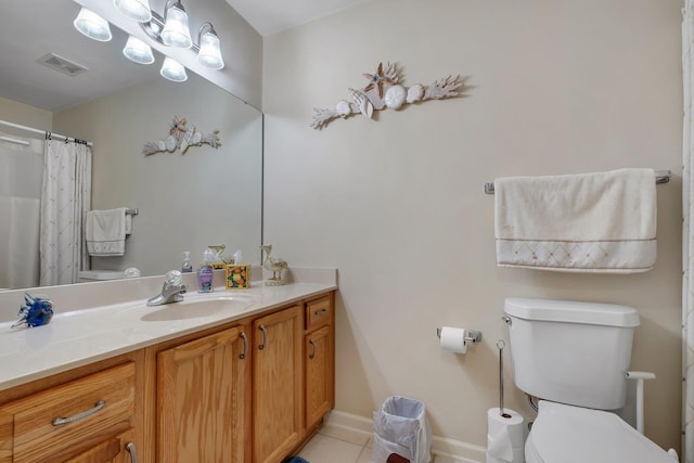 bathroom featuring toilet, tile patterned flooring, vanity, and baseboards