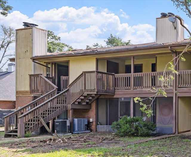 rear view of house with a chimney, central AC unit, and stairway