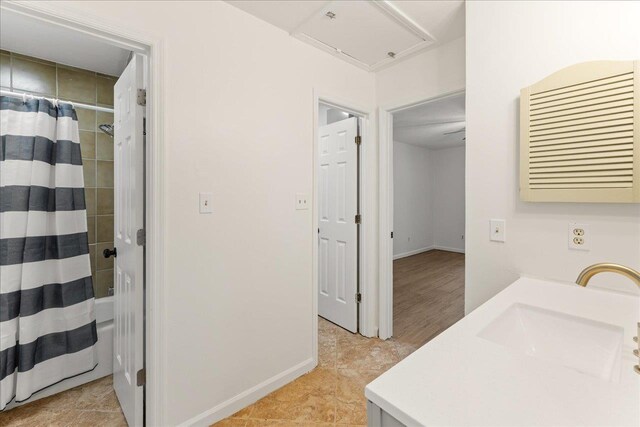 full bath featuring shower / tub combo, baseboards, and vanity