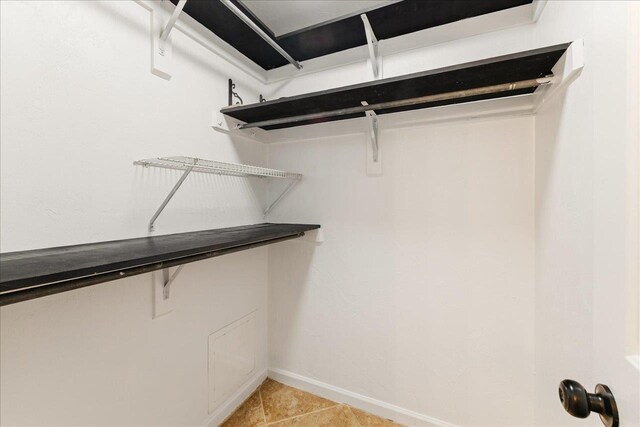 spacious closet with light tile patterned floors