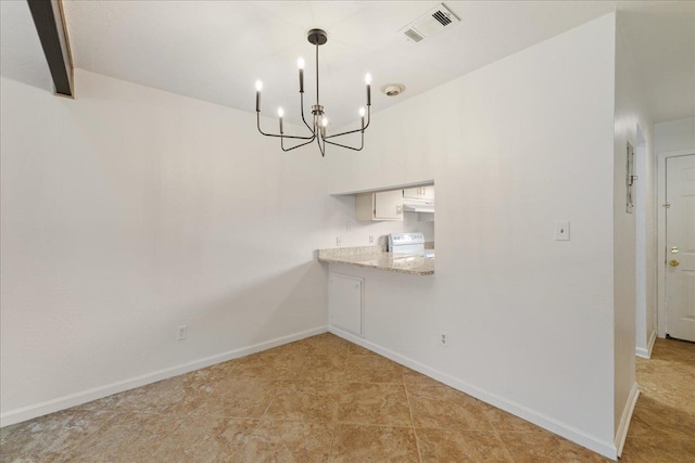 unfurnished dining area with baseboards, a chandelier, and visible vents