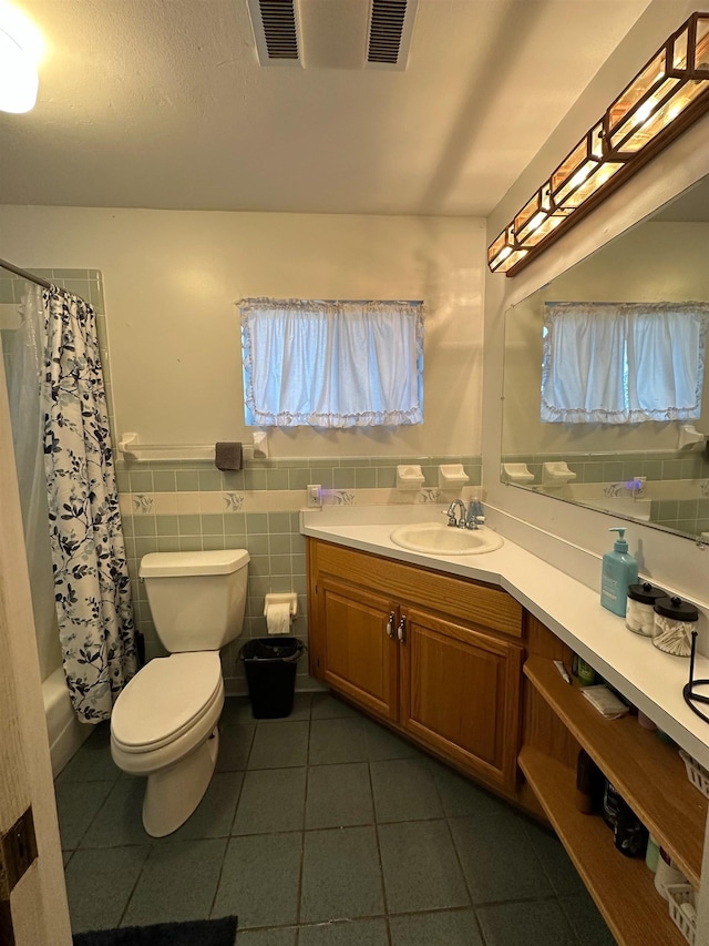 71 Royster Dr, Crawfordville, FL 32327 - full bathroom featuring vanity, toilet, tile patterned flooring, a wainscoted wall, and shower / bath combo