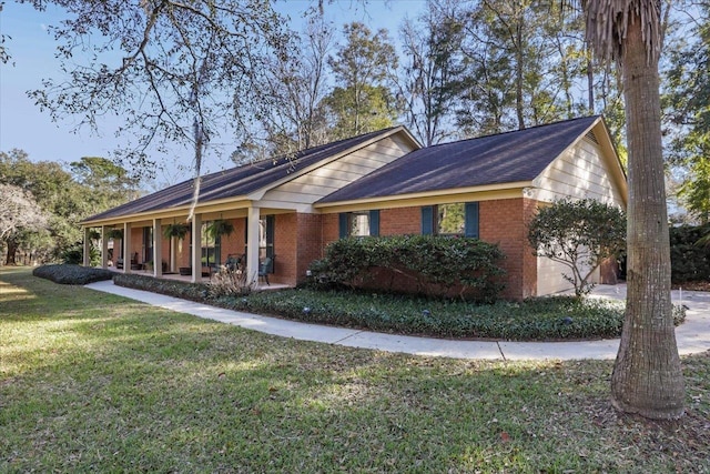 view of front of house featuring a garage, a front yard, and brick siding