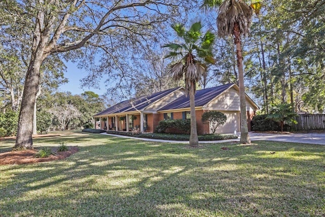 single story home featuring an attached garage, driveway, a front lawn, and brick siding