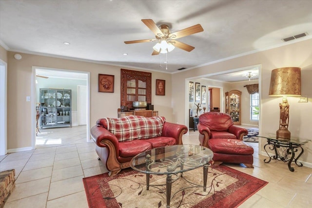 living area with light tile patterned floors, ornamental molding, visible vents, and baseboards