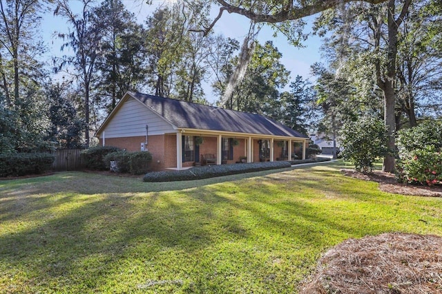 exterior space featuring a yard, fence, and brick siding