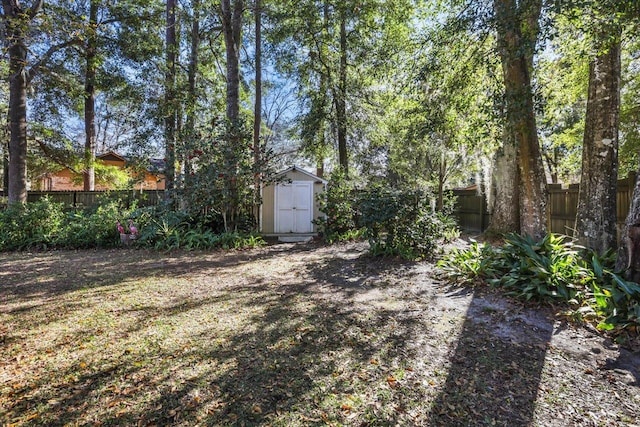 view of yard featuring a shed, an outdoor structure, and a fenced backyard