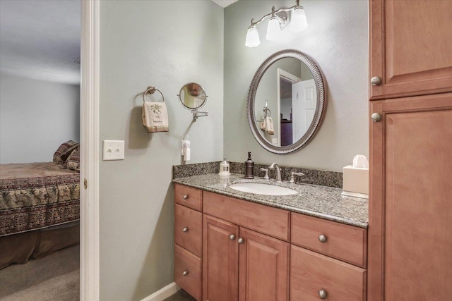 ensuite bathroom with ensuite bath, baseboards, and vanity