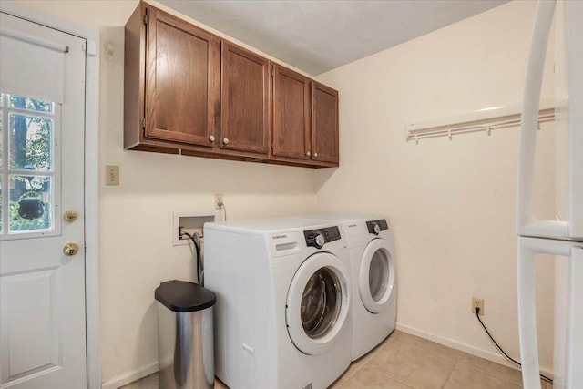 laundry room featuring light tile patterned floors, cabinet space, baseboards, and separate washer and dryer